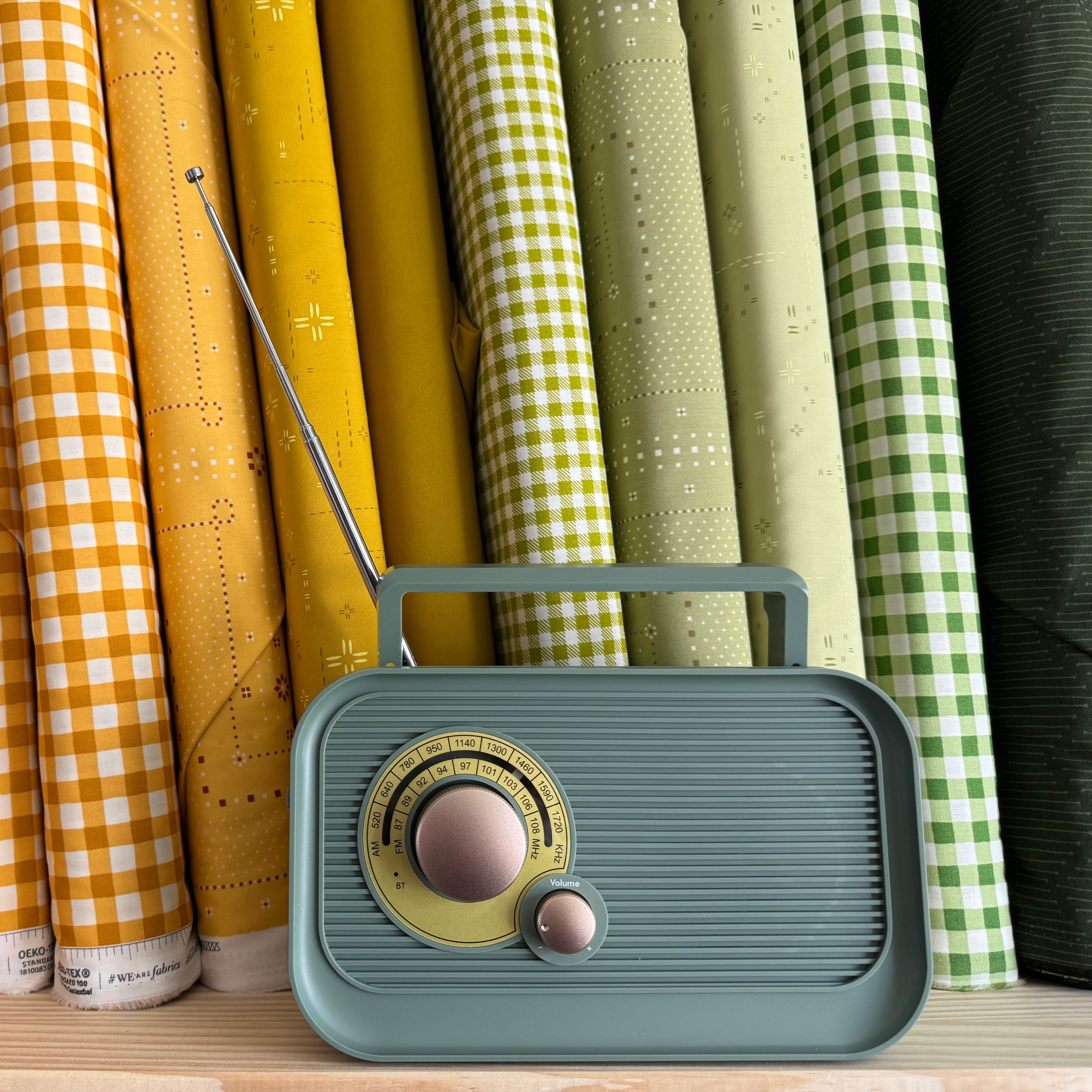 Vintage-style radio on a shelf with colorful fabric rolls in the background