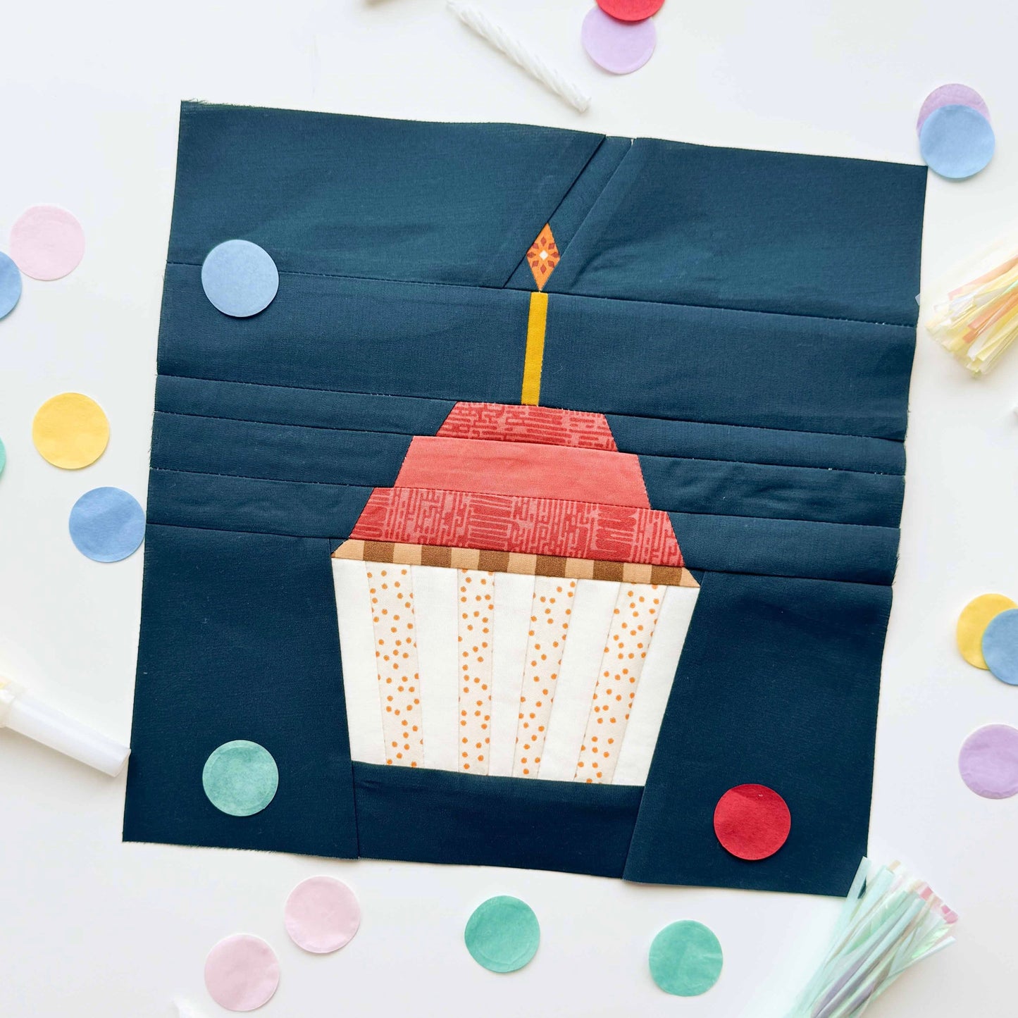 Patchwork square with a cake design on a white background with colorful confetti
