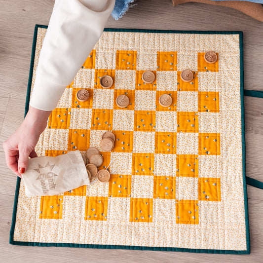 Checkered game board with wooden pieces on a wooden surface